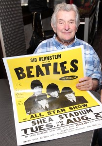 Sid Bernstein holding a Beatles concert poster. 